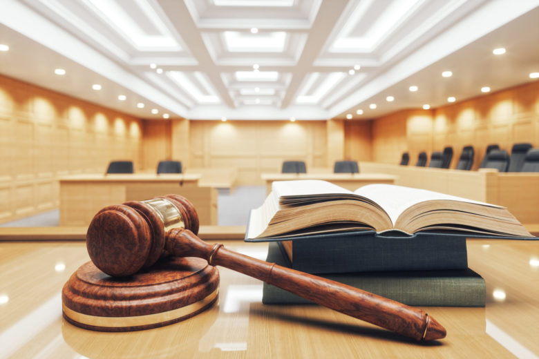 tuomarin vasara ja lakikirja tuomioistuimen pöydällä