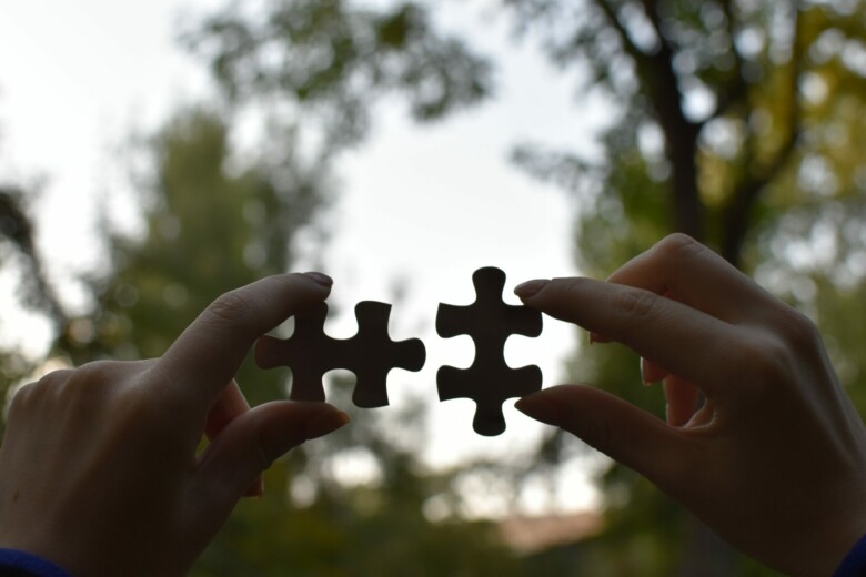 Holding puzzle pieces.