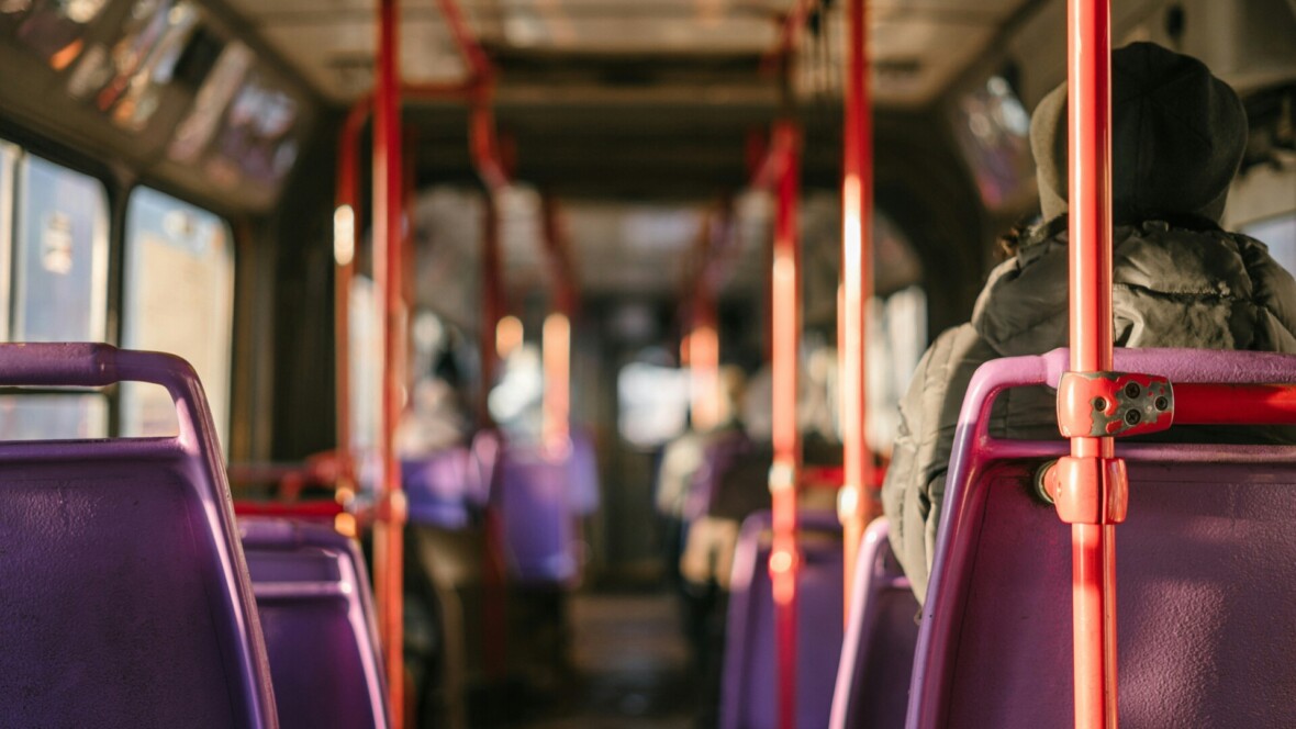 Kuva bussin sisältä. Kyydissä on yksi matkustaja, jota kuvataan takaapäin.
