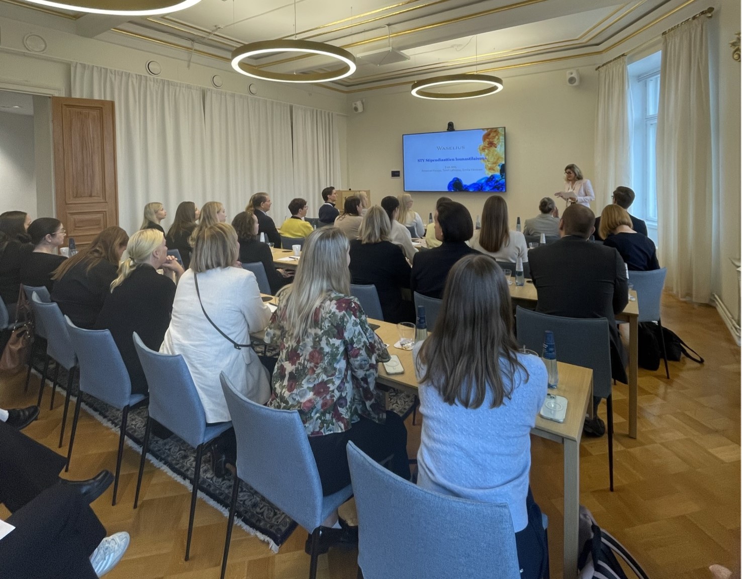 A person giving a presentation for a room full of people.