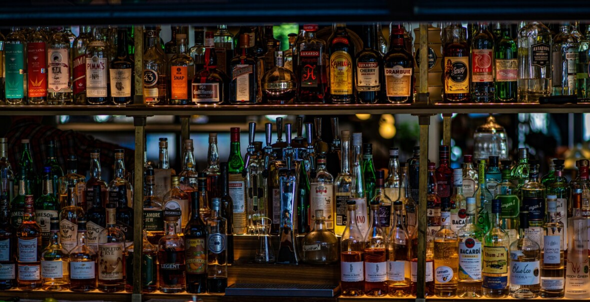 Paljon pulloja alkoholia hyllyillä.